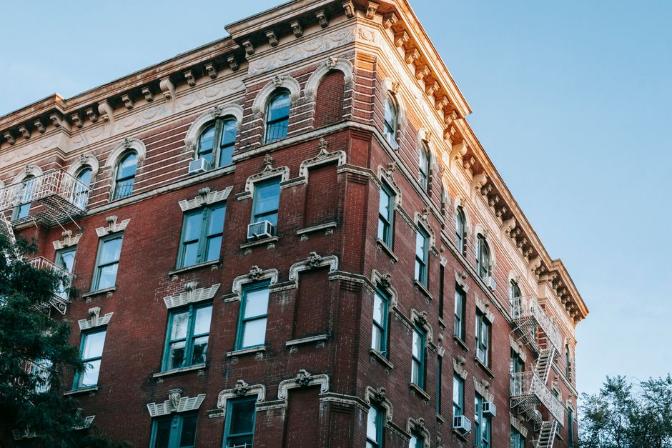 From below of historical building with windows located on street against cloudless sky