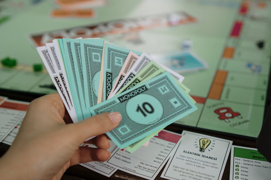 Hand holding colorful Monopoly money over a game board, symbolizing strategy and play.