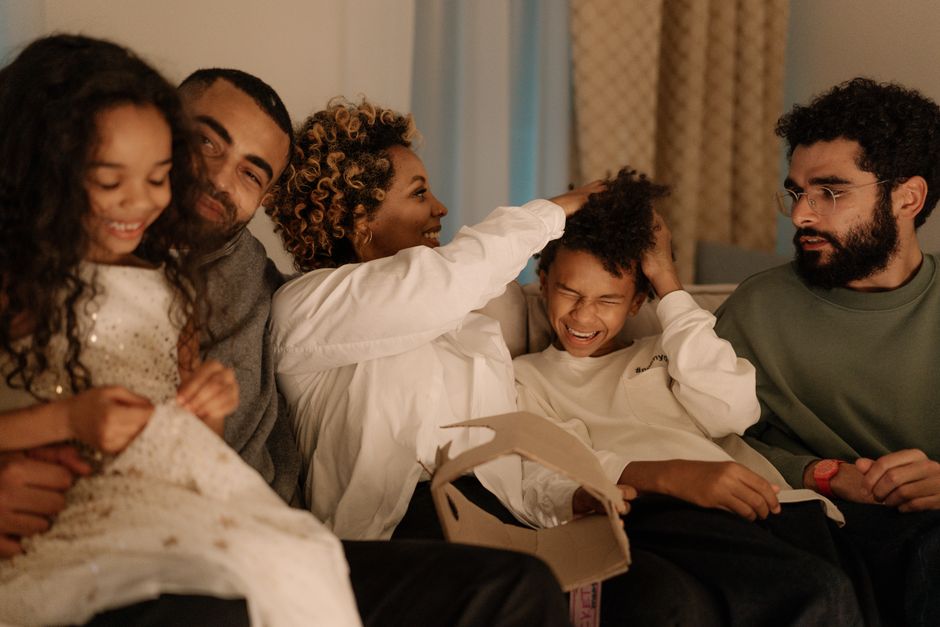 A happy family enjoys quality time together on a comfortable sofa, filled with smiles and laughter.