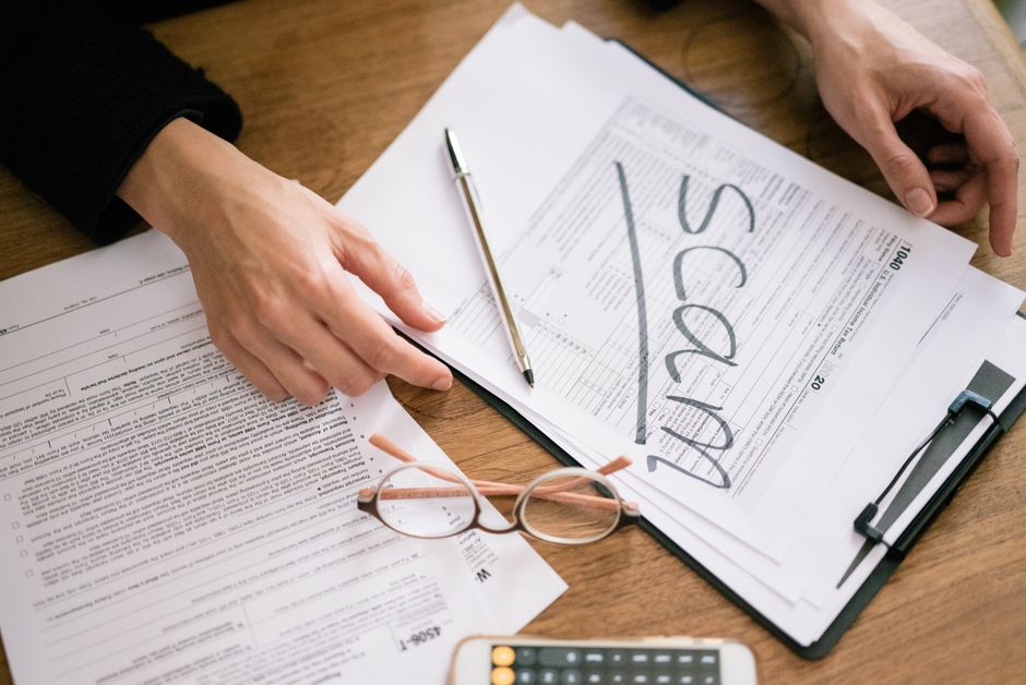 A close look at tax forms marked with scam, highlighting financial fraud risks.