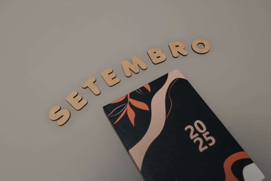 Stylish 2025 planner with abstract cover and 'Setembro' spelled out in wooden letters.